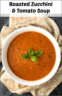 roasted zucchini and tomato soup in a white bowl with basil leaves on top