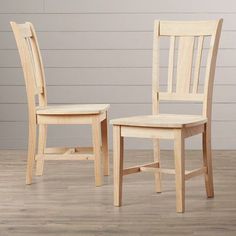 two wooden chairs sitting side by side on a hard wood floor