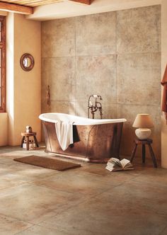 a bathroom with a large tub and tiled flooring, along with a wooden chair