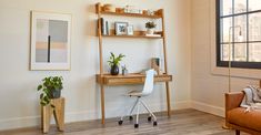 a room with a chair, desk and shelves on the wall next to a window