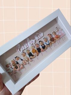 a person holding up a white box with pictures in it and the words cake on it