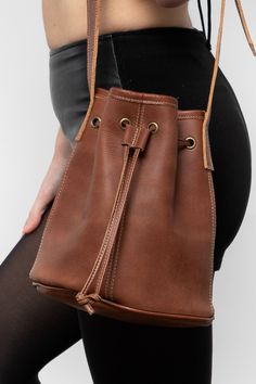 The Drawstring Bucket Bag is a classic that combines style and function. You’ll find that this spacious bag fits easily into your daily wardrobe. This artisanal product is made of genuine leather. All scars are characteristics of the skin and not imperfections. We hope you enjoy this unique handmade object. | Drawstring Bucket Bag for Women in Sand