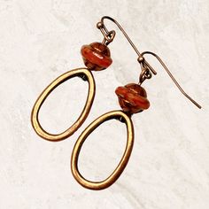 Hoop earrings in copper with burnt orange Czech glass beads. Sophisticated minimalist dangle earrings, lightweight and comfortable for all day wear. Fabulous fall earrings in a trending color. Stunning Saturn beads are capped with a copper finish. Artisan glass beads produced in small quantities in the Czech Republic. Hypoallergenic ear wires (nickel and lead free). Select ear wire style at checkout. A gift for you or someone special, earrings are carded and in an organza bag. Link back to my sh Brown Brass Drop Earrings, Nickel-free Rust Drop Earrings, Nickel-free Rust-colored Metal Jewelry, Bronze Wire Wrapped Hoop Earrings, Amber Copper Earrings As Gift, Handmade Brown Copper Hoop Earrings, Brown Copper Wire Wrapped Earrings, Copper Wire Wrapped Brown Earrings, Brown Copper Hoop Earrings For Gift