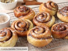 several cinnamon rolls on a cooling rack with powdered sugar