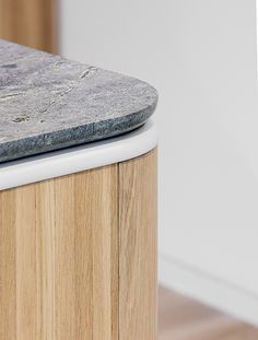 a close up of a counter top on a wooden cabinet with white trim and grey marble