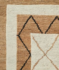 a brown and white area rug with an abstract design on the front, black lines in the middle