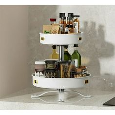 a three - tiered white tray holds bottles and condiments