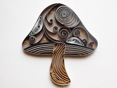 a brooch that is shaped like a tree with swirls and dots on it