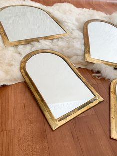 three mirrors sitting on top of a wooden floor next to a furnishing area