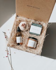 an open gift box containing three bottles of body care products and a soap in it