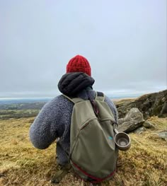 a person with a back pack on top of a hill