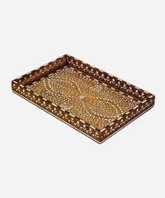 a brown tray with intricate designs on the bottom and sides, sitting on a white surface