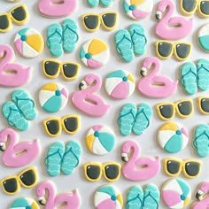 decorated cookies with sunglasses, flip flops and flamingos are displayed on a white surface