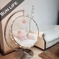 a living room with a white couch, chair and round mirror on the floor in front of it