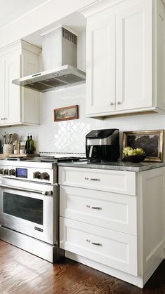 a kitchen with white cabinets and stainless steel appliances