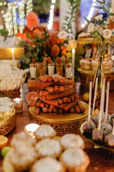 an assortment of desserts and pastries on a table in a room with lights