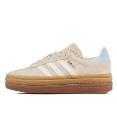 Description de la Adidas Gazelle Bold Wonder White Clear Sky Découvrez la Adidas Gazelle Bold Wonder White Clear Sky, une réinterprétation audacieuse d'un classique intemporel. Ce modèle d'Adidas Gazelle.bold beige se distingue par sa tige en daim blanc crème, sublimée par des touches de bleu clair au talon, apportant une fraîcheur et une élégance discrètes. Les célèbres trois bandes blanches sur les côtés et le logo doré "Gazelle" ajoutent une touche d'authenticité et de sophistication.  La sem Adidas Gazelle Beige, Adidas Gazelle Bold, Gazelle Bold, Tennis Shoes Outfit, Shoe Wishlist, Cute Nike Shoes, Shoe Inspo