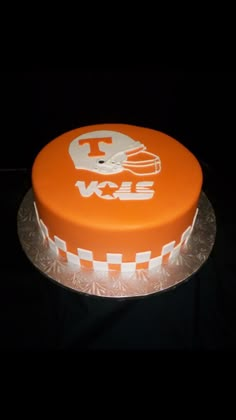 an orange cake with a football helmet on it's top and the words tennessee