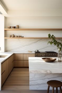 a kitchen with white marble counter tops and wooden shelves on the wall next to an island