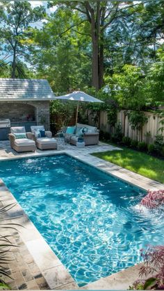 a backyard with a pool and patio furniture