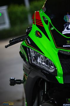 the front end of a green and black motorcycle