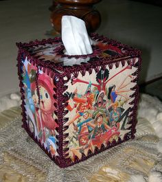 a tissue dispenser sitting on top of a white tablecloth covered floor