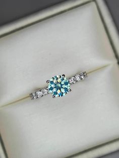 a blue and white diamond ring in a box