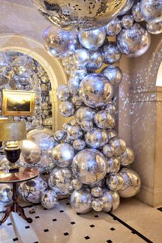 a room filled with lots of shiny silver balls and a large mirror ball hanging from the ceiling