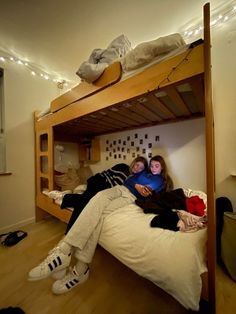 two people laying on a bunk bed in a room