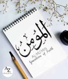 a notebook with arabic writing on it next to a pen