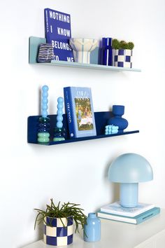 two shelves with books and vases on them