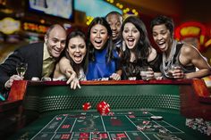 a group of people playing roulejack in a casino