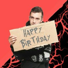 a man holding a sign that says happy birthday