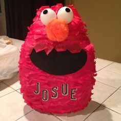 a close up of a paper mache character on a tile floor near a table