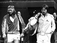 two tennis players are walking down the street with their rackets in hand and headbands on