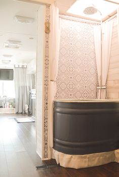 a bath tub sitting inside of a bathroom next to a shower stall with curtains on it