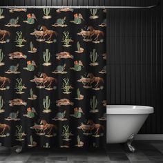 a black shower curtain with horses and cactuses on it in a bathroom next to a bathtub