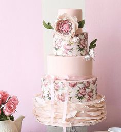 a three tiered cake with pink flowers on it