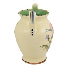 a white vase with flowers painted on the side and blue stripes around the top, sitting against a white background