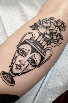 a woman's face with flowers on her arm