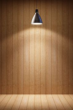 an empty wooden room with a lamp on the wall and wood paneled walls behind it