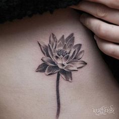 a woman's stomach with a flower tattoo on it