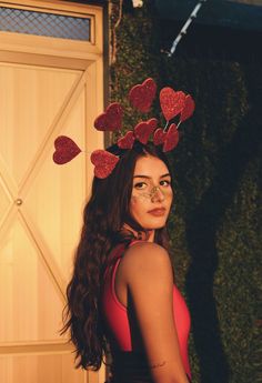 a woman in a red dress with hearts on her head