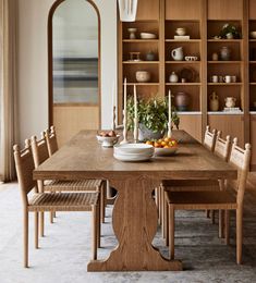 a dining room table with chairs and plates on it