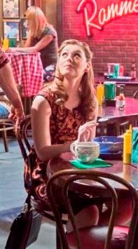 a woman sitting at a table in a restaurant