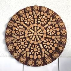 a wooden plate with wine corks in the shape of a flower on a tile wall