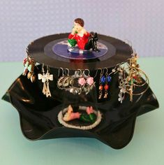 a record player with many charms attached to it's sides on a blue surface