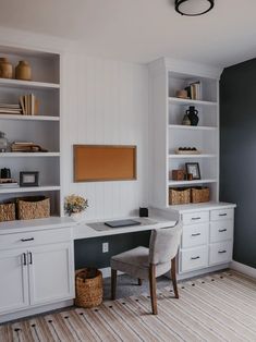 a home office with built - in shelving, desk and storage units on the wall