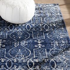 a large blue rug with an ornate design on it and a white poufce