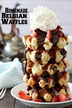 a stack of waffles topped with whipped cream and strawberries on a plate